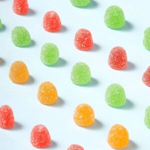 Close-up of bright orange and yellow Vitamin C gummies showing their soft, bouncy texture.